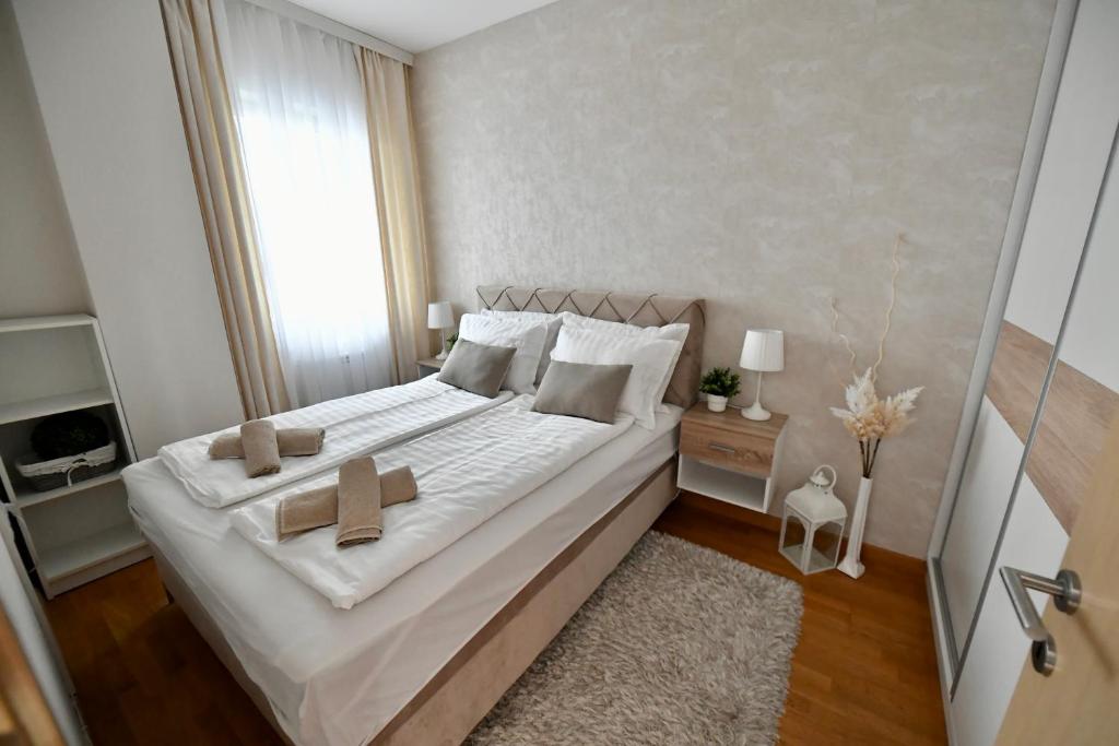 a bedroom with a large bed with two crosses on it at Apartman SUN in Inđija