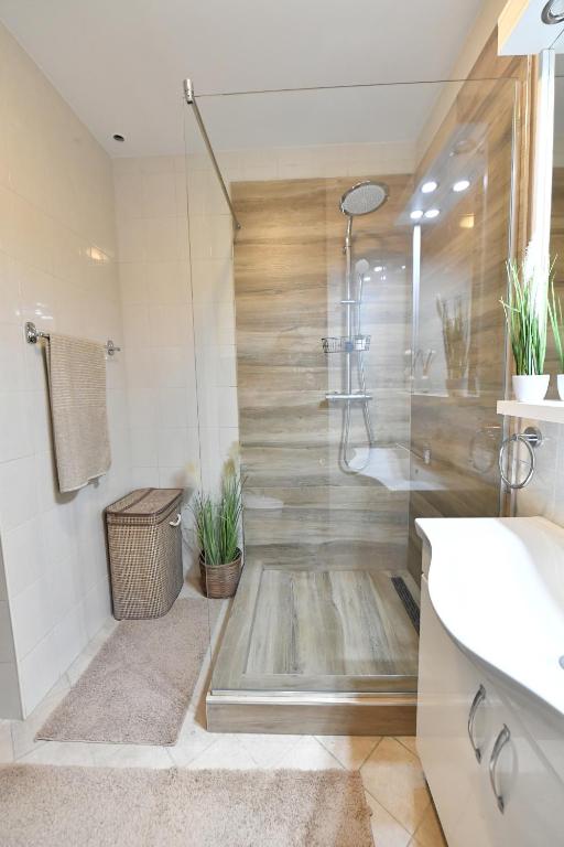 a bathroom with a shower with plants in it at Apartman SUN in Inđija