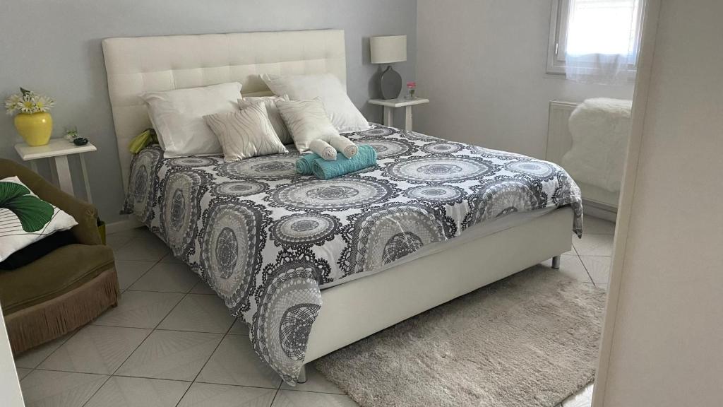 una camera da letto con un letto con un piumone bianco e nero di Maison quiétude a Chavanoz