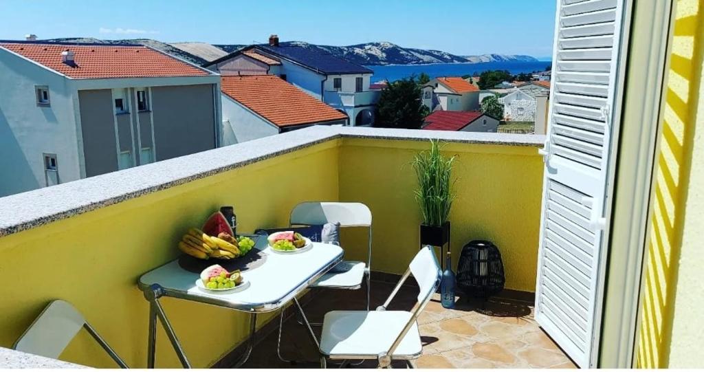 un balcone con un tavolo con banane e frutta sopra di Sunshine Apartment a Stara Novalja