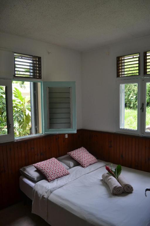 a bedroom with a bed with two pillows on it at Télétravail et Plaisir au soleil avec vue mer! in Bouillante