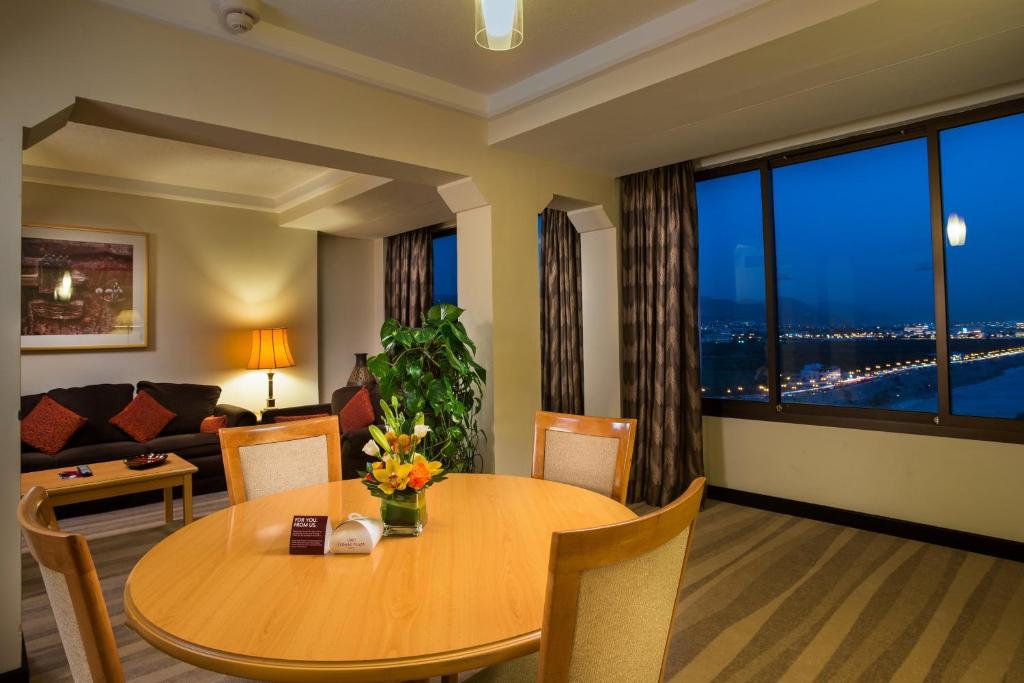 馬斯喀特的住宿－馬斯喀特皇冠假日酒店，客厅配有桌子和沙发