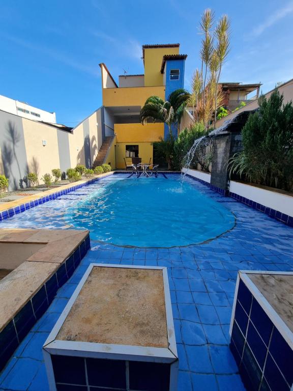 a swimming pool in front of a building at Residência Wimbledon in Ilhéus