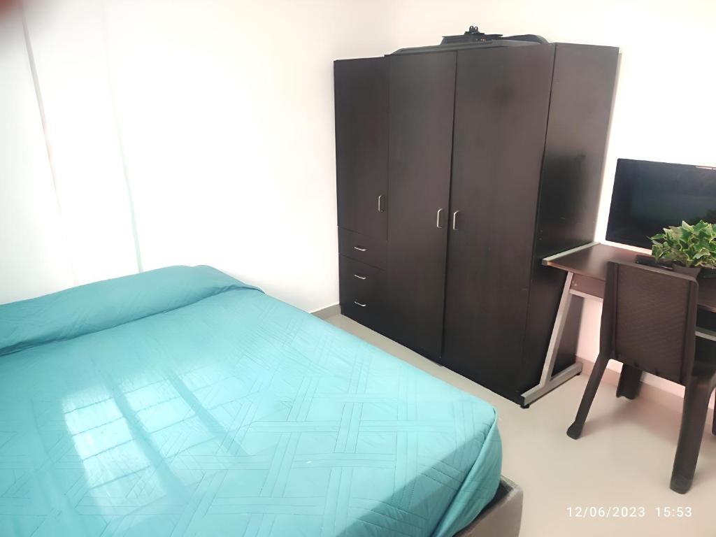a bedroom with a bed and a desk and a computer at Habitación en casa ambiente familiar in Cartagena de Indias