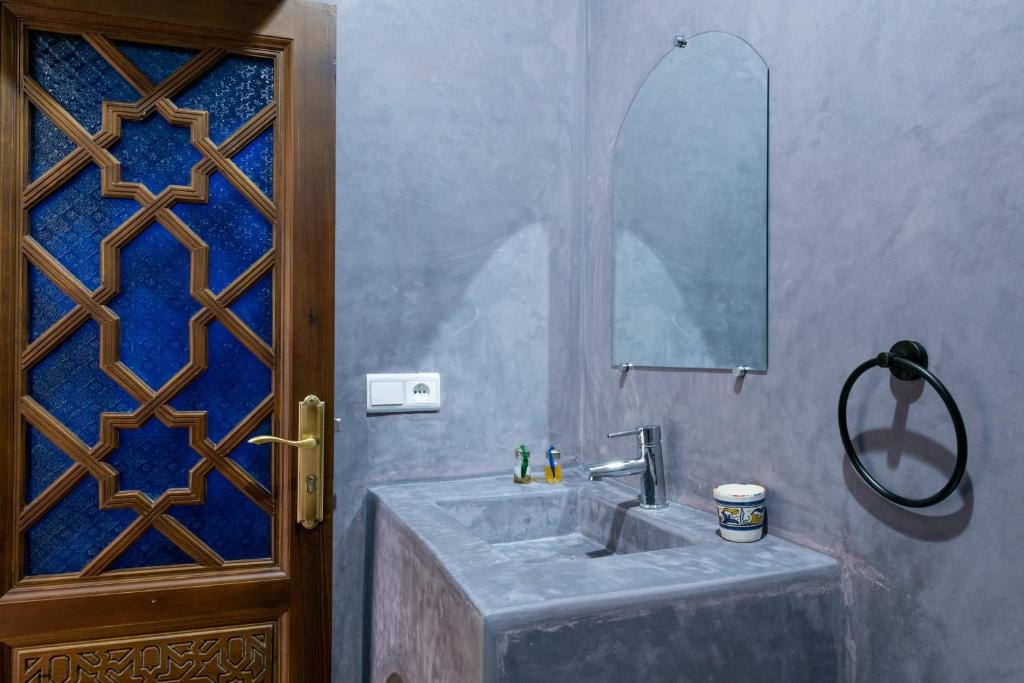 a bathroom with a sink and a mirror at Riad SULTANA in Tangier