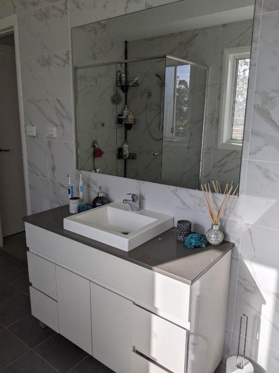 un bagno con un lavandino bianco e uno specchio di Country Lane a Denham Court