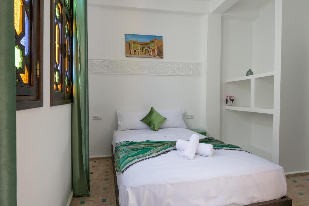 a bedroom with a bed with a cross on it at Riad SULTANA in Tangier