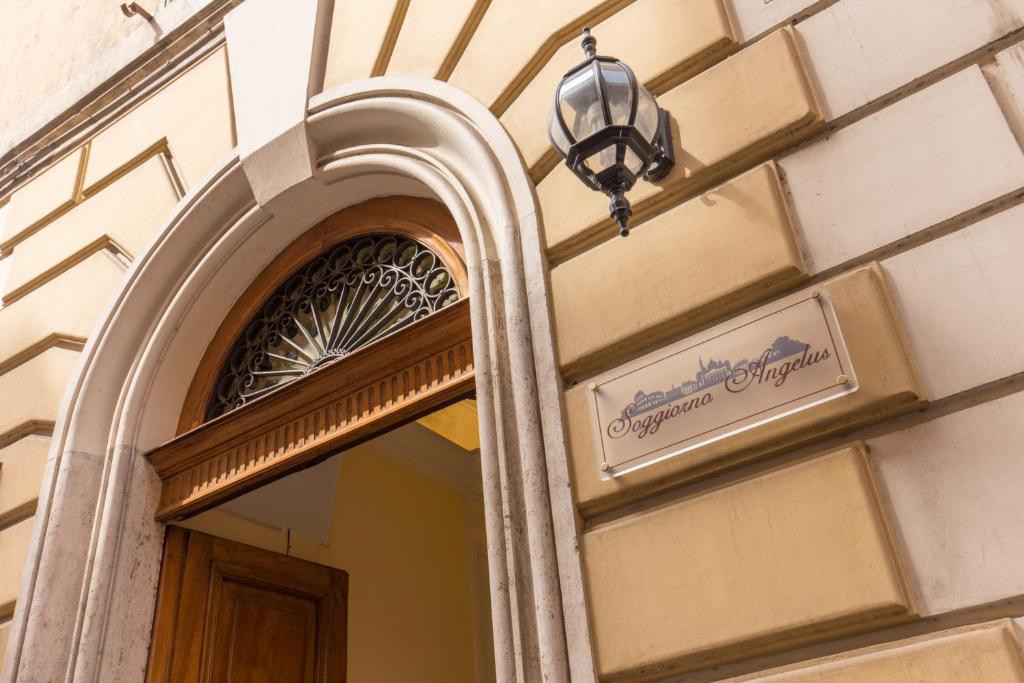 un panneau sur le côté d'un bâtiment avec un miroir dans l'établissement Soggiorno Angelus, à Rome