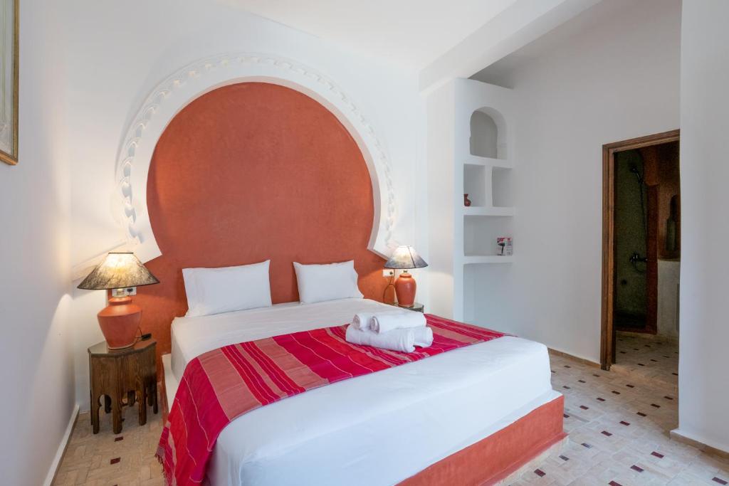 a bedroom with a large white bed with an arch overhead at Riad SULTANA in Tangier
