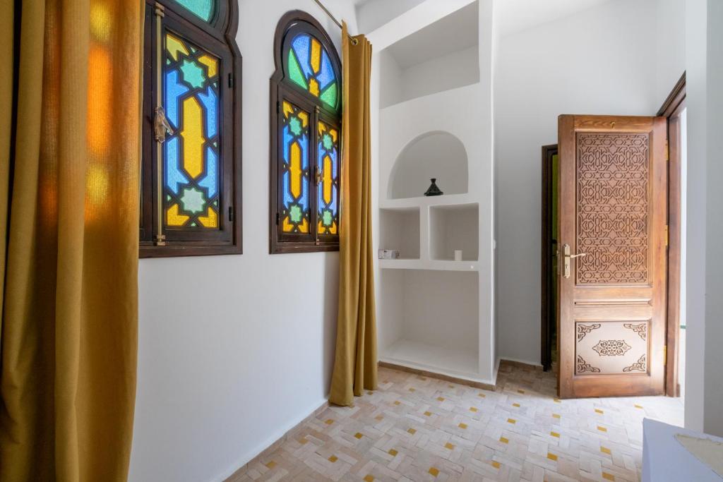 a hallway with two stained glass windows and a door at Riad SULTANA in Tangier