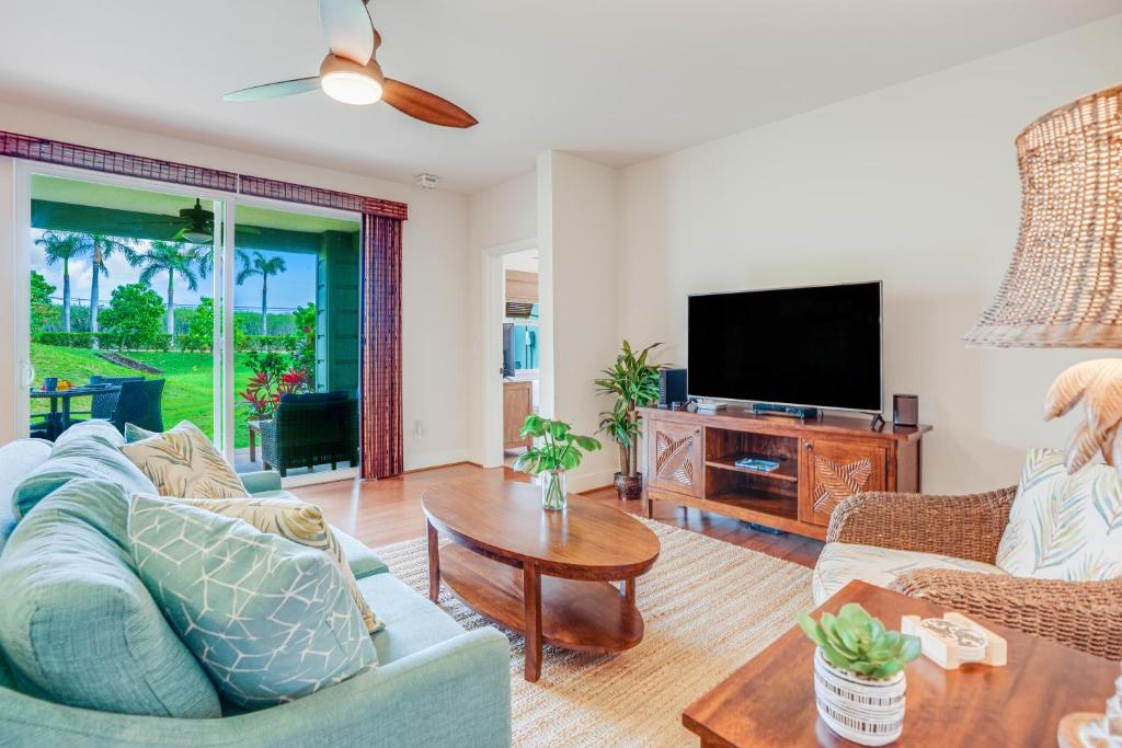 a living room with a couch and a tv at Pili Mai 1A in Koloa