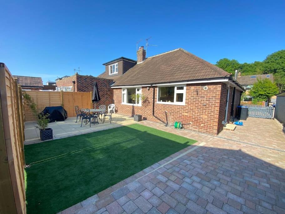 a backyard with a lawn and a brick house at Home in Harrogate in Harrogate