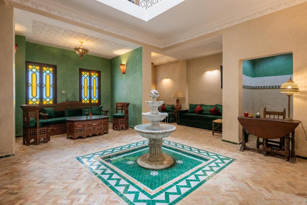 ein Wohnzimmer mit einem Brunnen in der Mitte eines Zimmers in der Unterkunft Riad SULTANA in Tangier