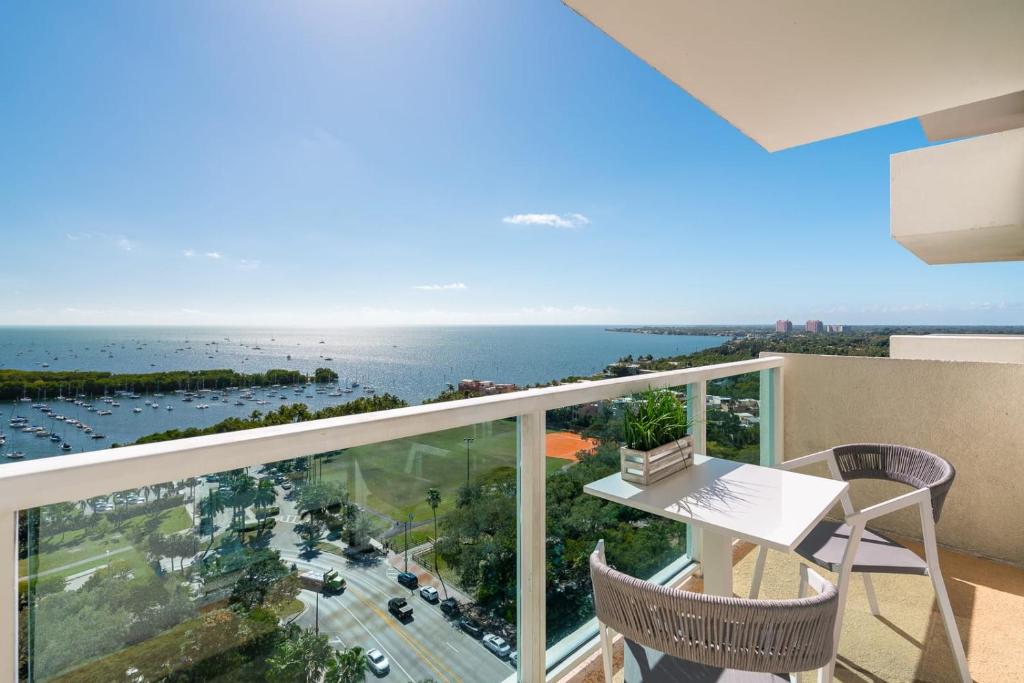 un balcon avec une table et des chaises et l'océan dans l'établissement Ocean View Balcony steps from Restaurants, Peacock Park & Marina, à Miami