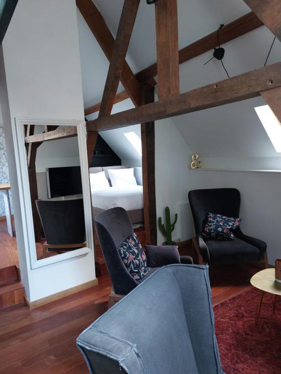 a living room with two chairs and a mirror at Loft de la raquette in Mons