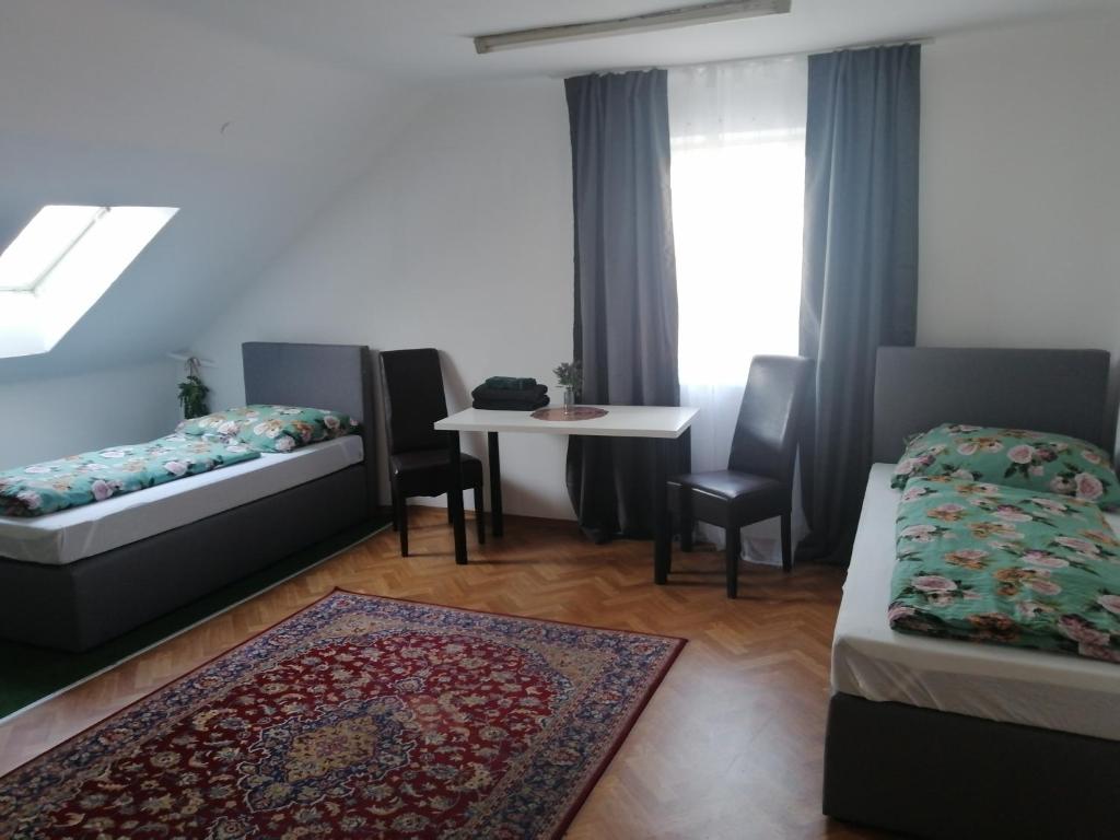 a room with two beds and a table with chairs at ApartGraz in Graz