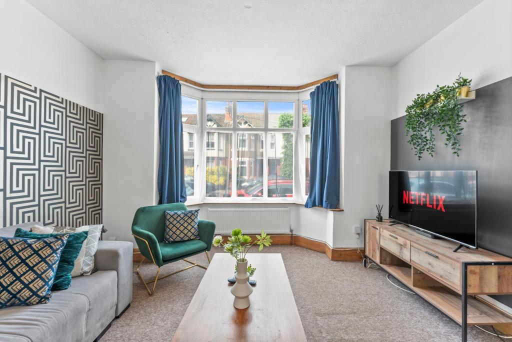 a living room with a couch and a tv at Large Stylish Home - Close to The City - Garden in Spon End