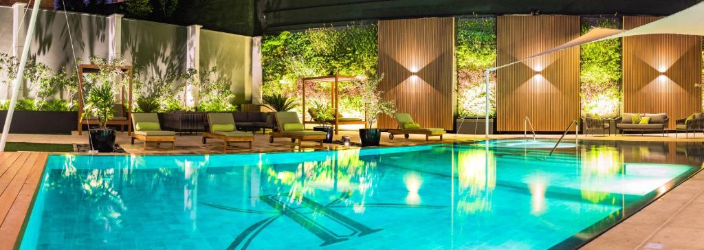 una gran piscina con sillas y una mesa en Adriatika Hotel & Residence, en Guatemala