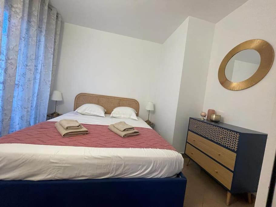 sypialnia z łóżkiem z lustrem i komodą w obiekcie 2/3 pièces avec terrasse à NICE w Nicei