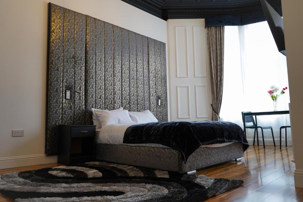 a bedroom with a bed with a black wall at Novana Aparthotel in Glasgow