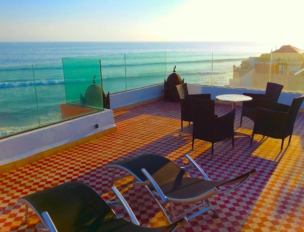 a room with chairs and a table and the ocean at Bouad Luxury Apartment in Taghazout