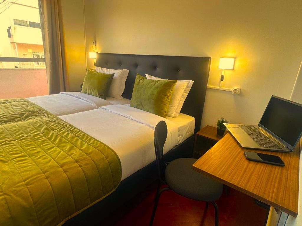 una camera d'albergo con un letto e un computer portatile su una scrivania di LISABONNA GUEST HOUSE a Lisbona