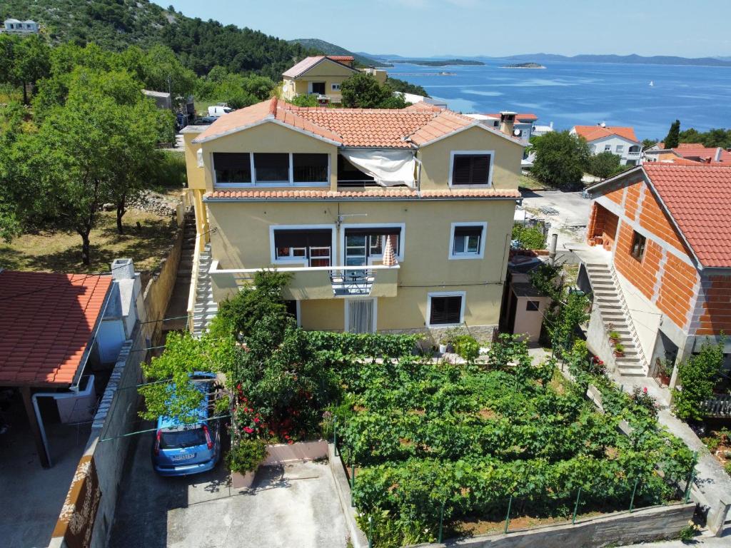 Apartments with a parking space Sali, Dugi otok - 16324 في سالي: منزل مع حديقة أمام المحيط