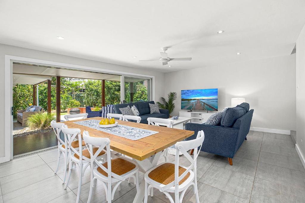 a living room with a wooden table and chairs at North Beach in Mylestom