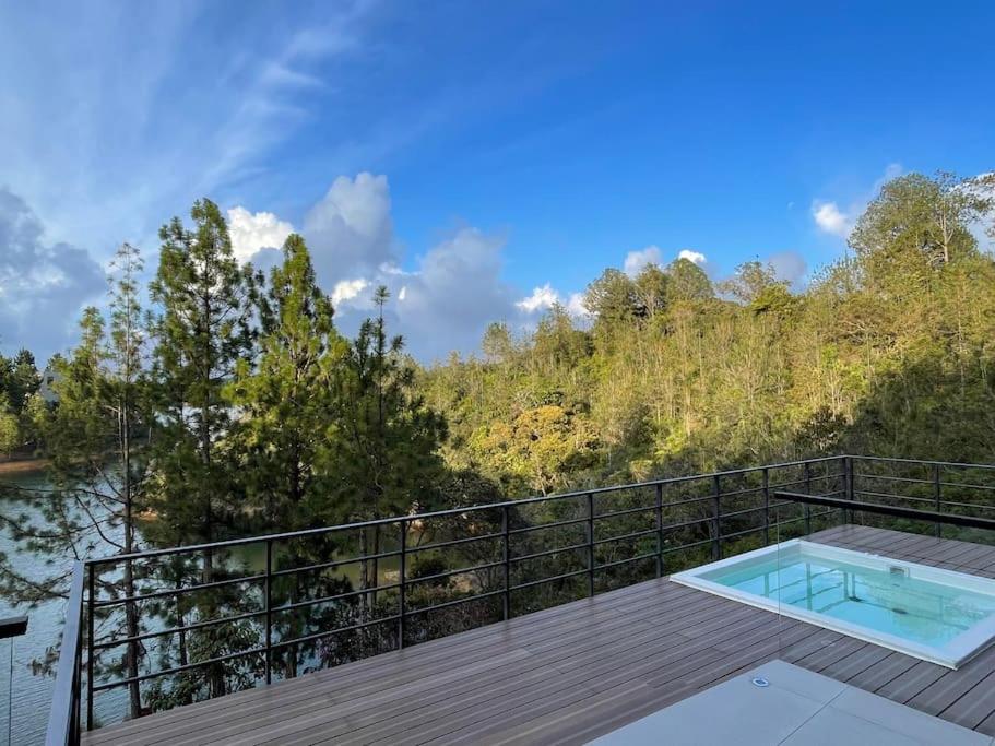 una terraza con piscina en la parte superior de una casa en Aqua Guatapé - Lakeside Luxury Villa, en Guatapé