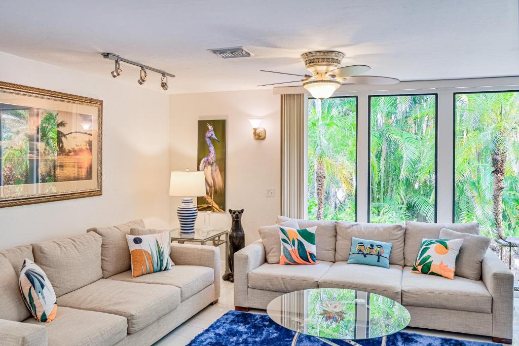 a living room with two couches and a glass table at The Rainbow Villa in Naples