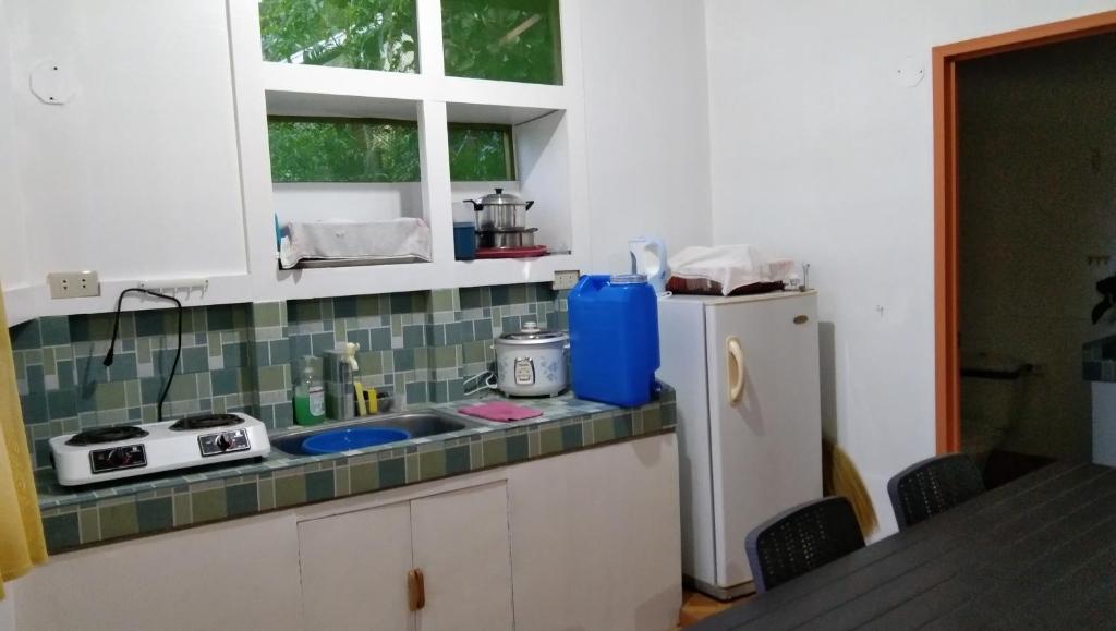 a kitchen with a sink and a refrigerator at Havilah House Baguio City in Baguio