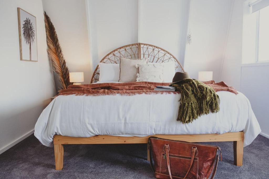 a bedroom with a large bed with a wooden headboard at Reardon Retreat in Port Fairy