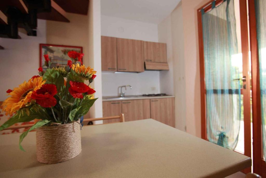 un jarrón de flores sentado en una mesa en una cocina en Apartment in Rosolina Mare 44965, en Rosolina Mare