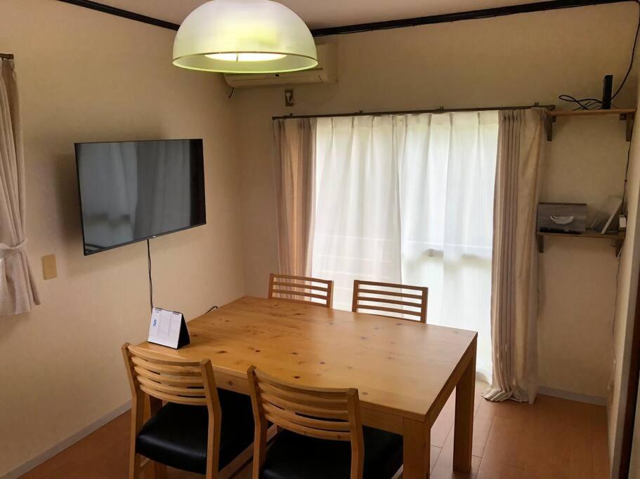 mesa de comedor con sillas y TV de pantalla plana en Chichibu Mizuno-stay 水野ステイ最大６名様 en Chichibu