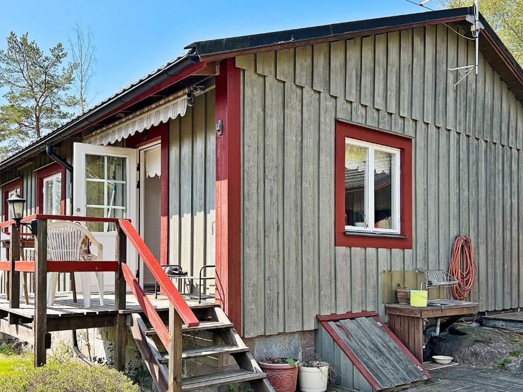 ein kleines Holzhaus mit einer roten Tür und einer Treppe in der Unterkunft Holiday home NYNÄSHAMN in Nynäshamn