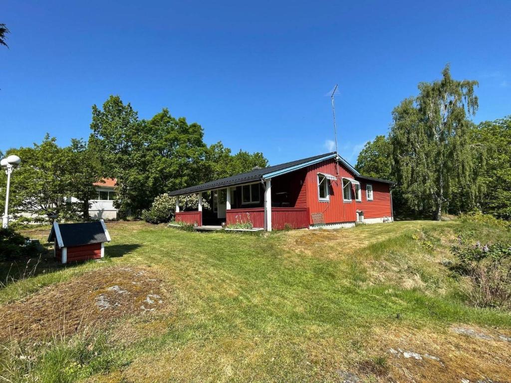 a red and black house on a grassy hill at Holiday home Nösund IX in Nösund