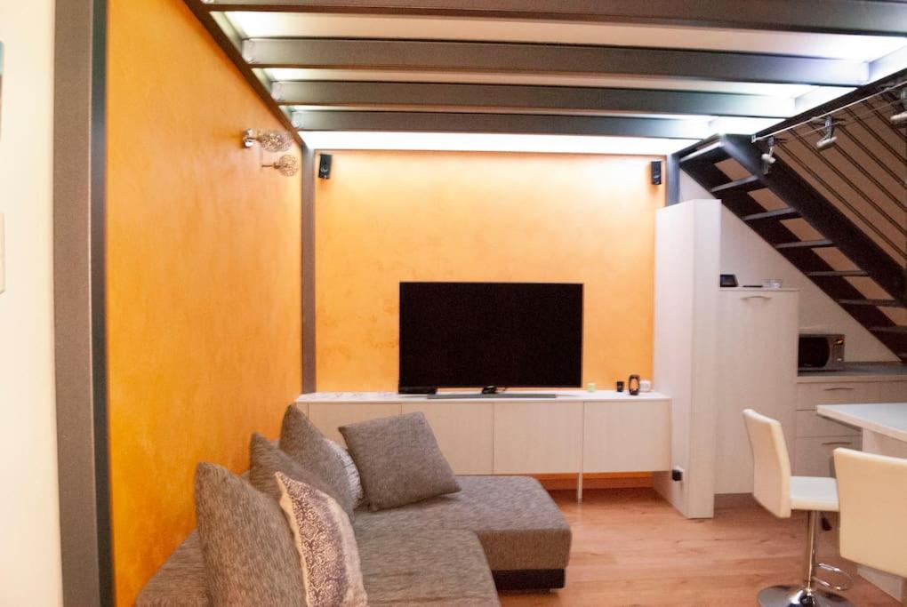 a living room with a couch and a flat screen tv at Mo&Vi - Elegante Loft - Vicino F1-San Gerardo-Parco Monza in Lissone