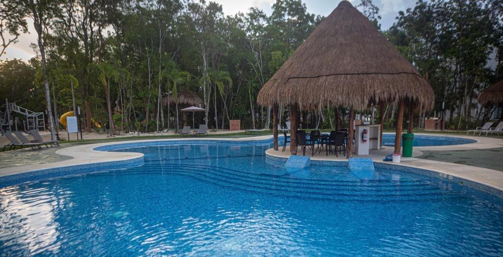 - une grande piscine avec un parasol dans l'établissement Casa Tucan. A contemporary holiday or work nest, à Puerto Morelos