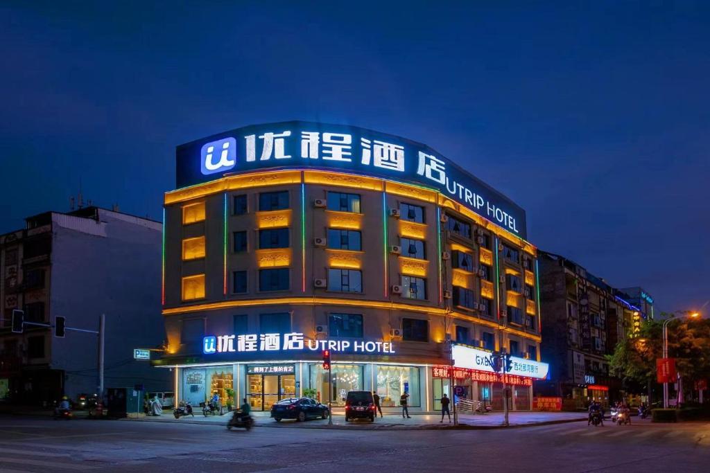 un edificio con un cartel encima por la noche en Unitour Hotel, Chongzuo Longzhou Red Eight Army Plaza 