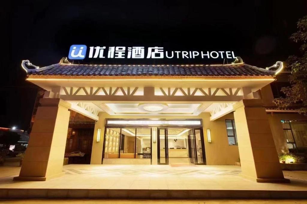 a building with a sign on top of it at Unitour Hotel, Chongzuo Rolling Mountain Road 
