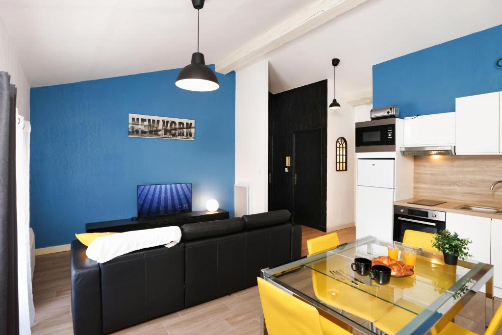 un salon avec un canapé noir et un mur bleu dans l'établissement City in' BLUE : 1 à 4 personnes, à Carcassonne