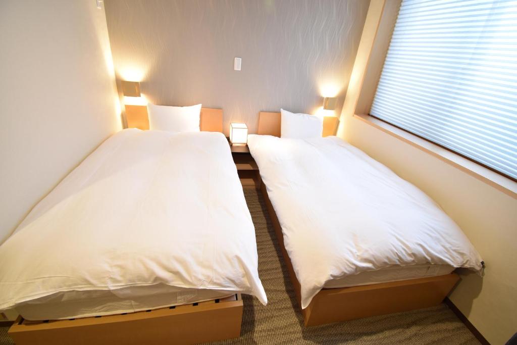 Postel nebo postele na pokoji v ubytování K-style 東本願寺