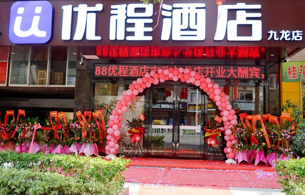 una tienda frente con un arco rosa con flores en Unitour Hotel, Yulin City Government, en Yulin