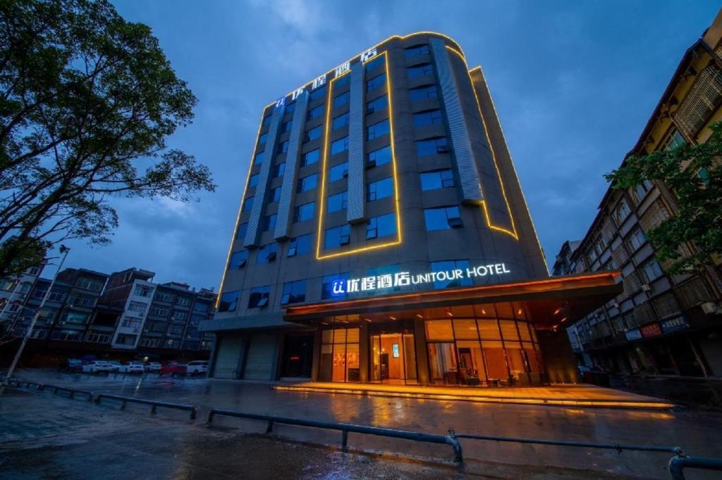 een gebouw met een bord aan de voorkant bij Unitour Hotel, Yulin Xingye High -speed Railway Station in Shinan