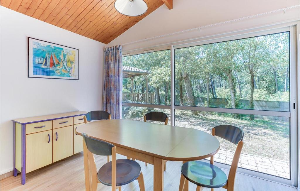 a dining room with a table and chairs and a window at 2 Bedroom Beautiful Home In La Faute-sur-mer in La Faute-sur-Mer