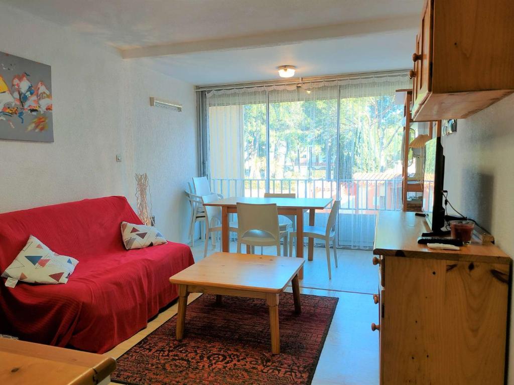 - un salon avec un canapé rouge et une table dans l'établissement Appartement Argelès-sur-Mer, 2 pièces, 6 personnes - FR-1-225-792, à Argelès-sur-Mer