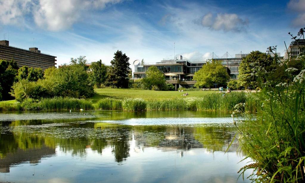 a view of a pond with buildings in the background at University of Bath Summer Accommodation in Bath