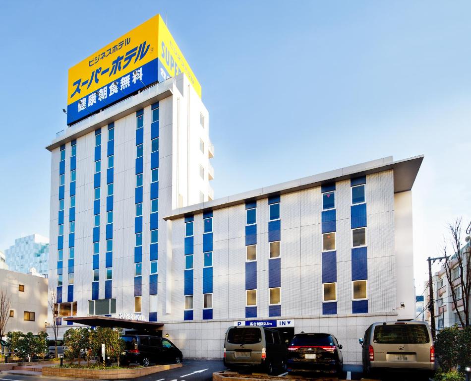 a building with cars parked in front of it at Super Hotel Tokyo Kameido in Tokyo