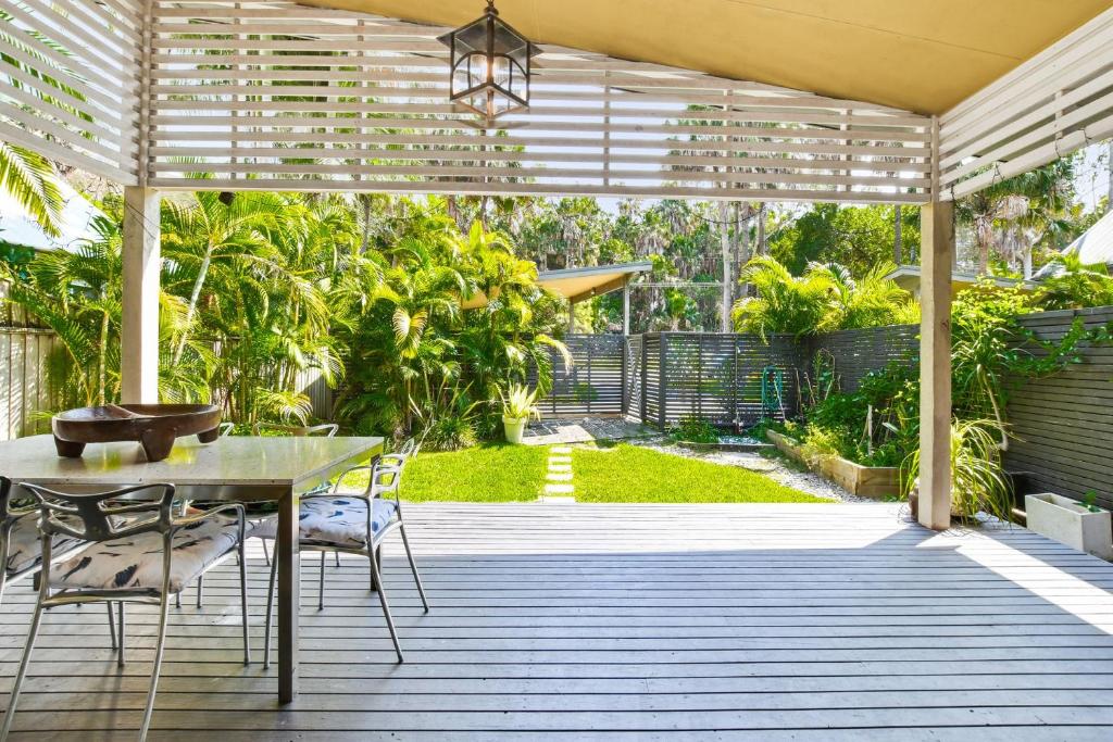 a patio with a table and chairs under a pergola at Bessou in Charlotte Bay