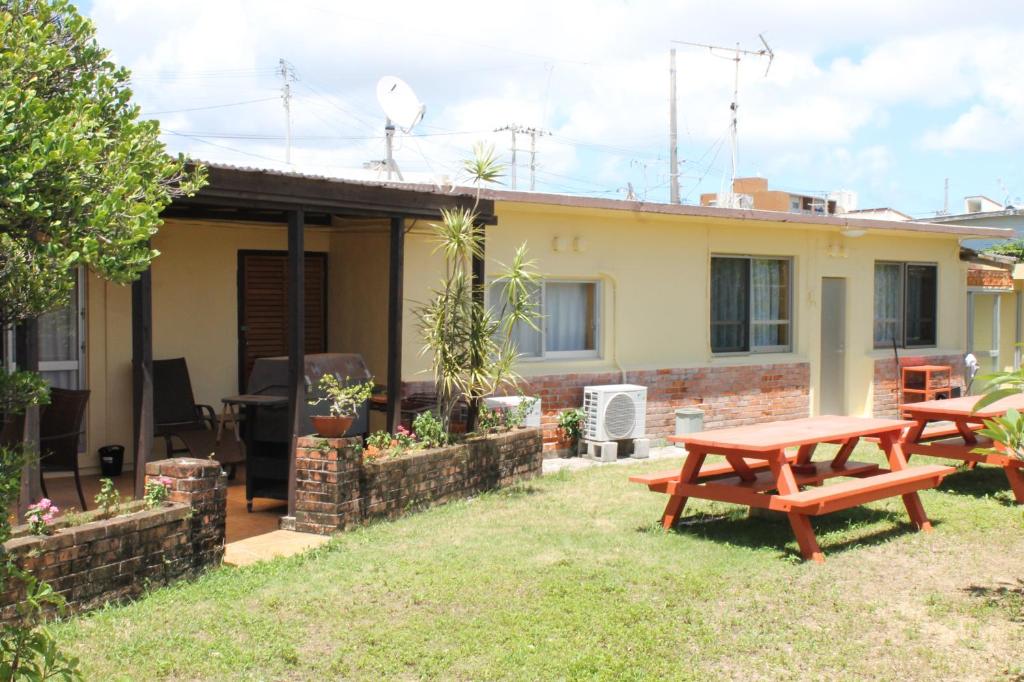 a house with a picnic table in the yard at 北谷 vacation house MALAPUA in Chatan